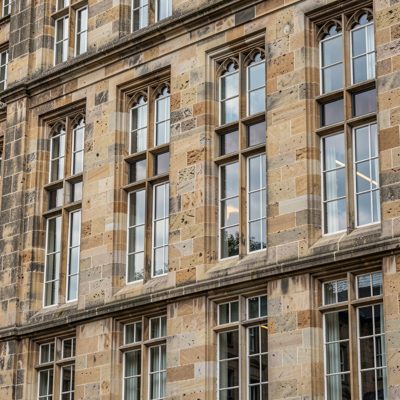 the facade of a historic stone building with tall windows
