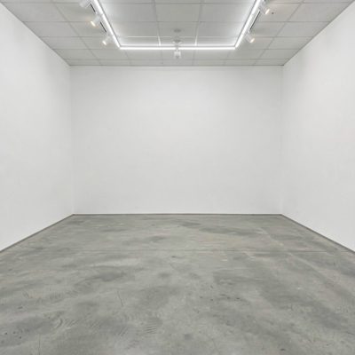 an empty gallery space with white walls and polished floors