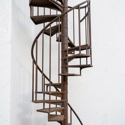 a cast iron spiral stair against a white wall