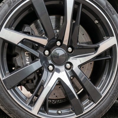 an alloy wheel photographed close with brake caliper behind