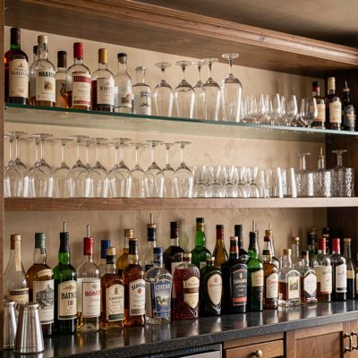 a shelf of glassware above a back bar