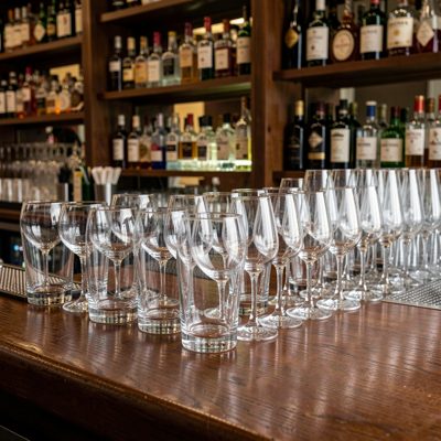 a row of empty glasses on a bar after service