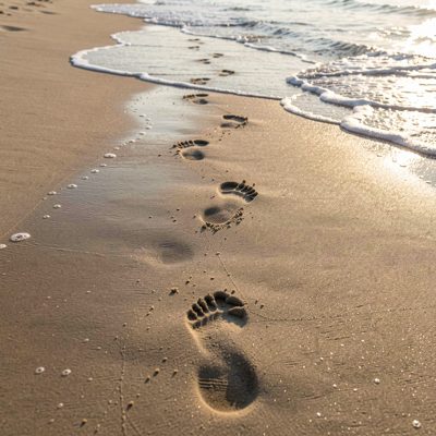 footprints leading across wet sand