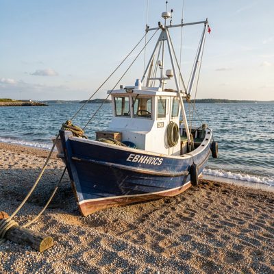 a fishing boat pulled up on shingle