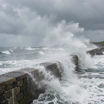 a coastal storm with spray over a wall