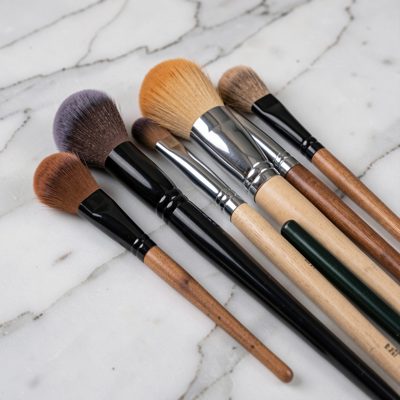 makeup brushes arranged on a marble surface