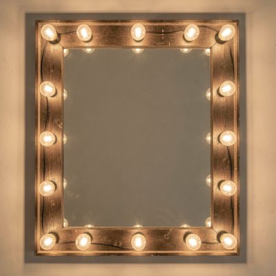 a mirror lit by bulbs around the frame