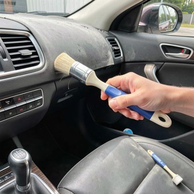 a car interior being detailed with a brush