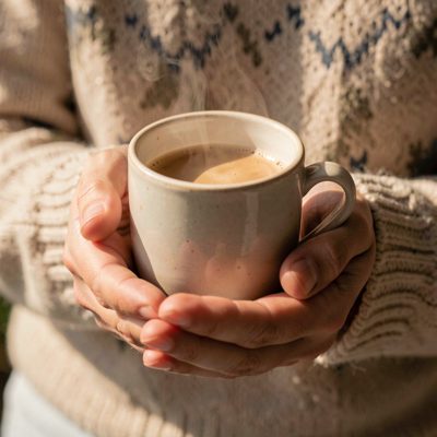 a hand holding a warm cup with both palms