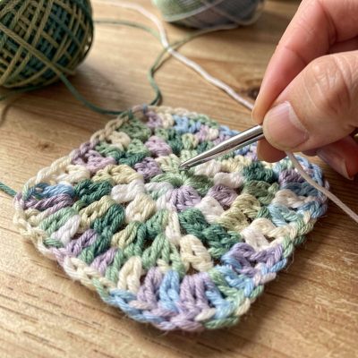 a crochet hook working a granny square