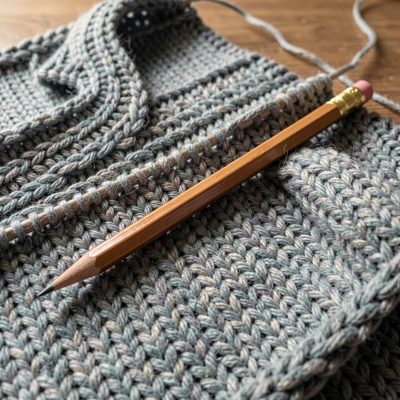 a knitting pattern with a pencil on it
