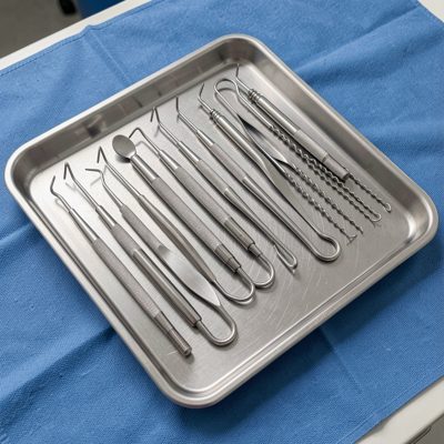 a tray of dental instruments on a blue cloth