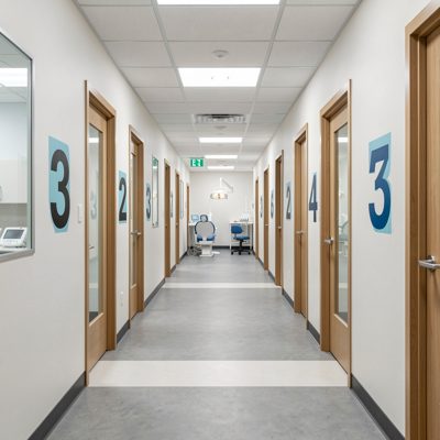 a dental clinic corridor with numbered rooms
