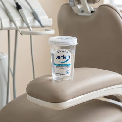 a mouthwash cup on the arm of a dental chair