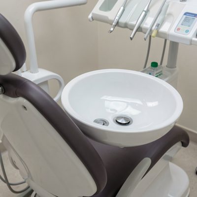a rinse basin beside a dental chair