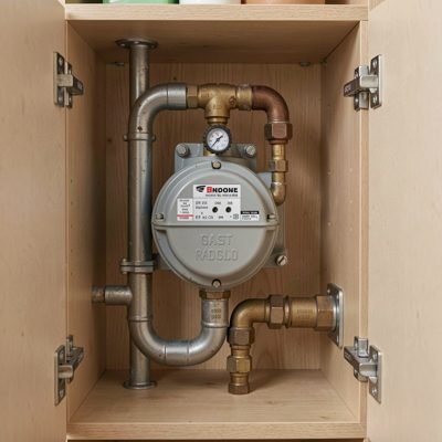 a gas meter and pipework in a cupboard