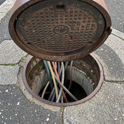 a manhole open with cabling below