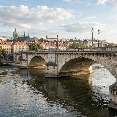 a bridge over a river with a city behind