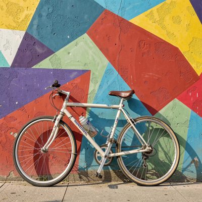 a bicycle parked against a painted wall