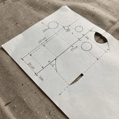 a pattern being cut from paper on fabric