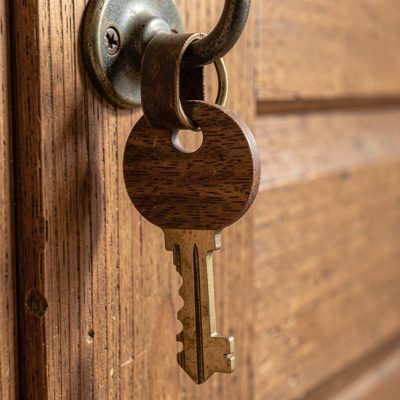a key on a wooden fob hanging on a hook