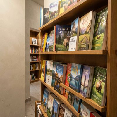 a shelf of local guidebooks in a hallway