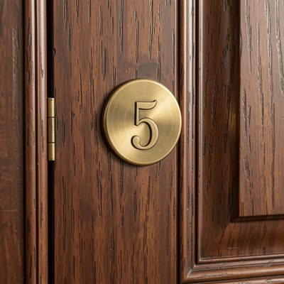 a bedroom door with a brass number on it