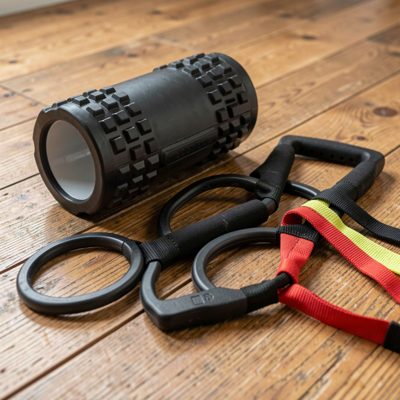 a foam roller and resistance bands on a wooden floor