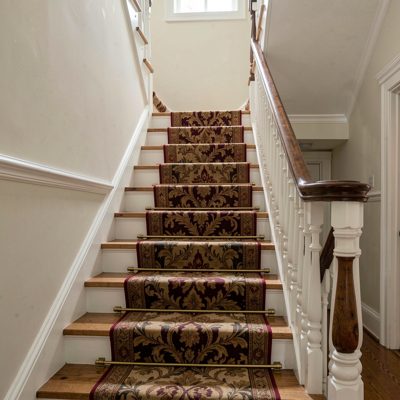 a staircase with a runner and banister