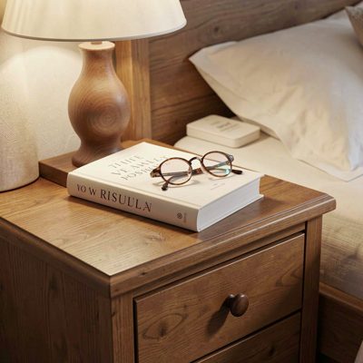 a bedside table with a book and glasses