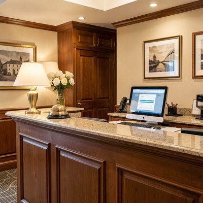 a hotel reception desk with a bell and a computer
