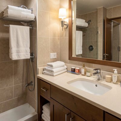 a hotel bathroom with folded towels and toiletries