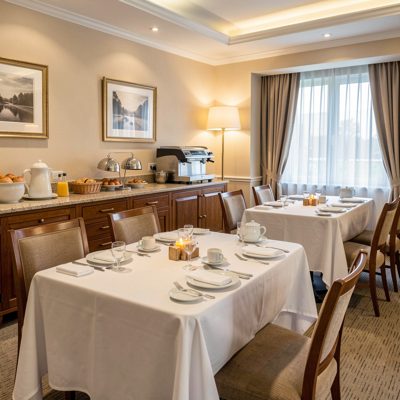 a hotel breakfast room set with white cloths