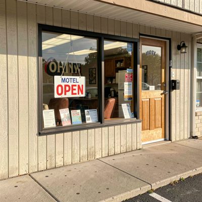 a motel office with an open sign in the window