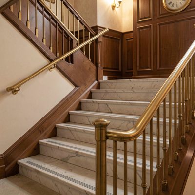 a hotel staircase with a brass handrail