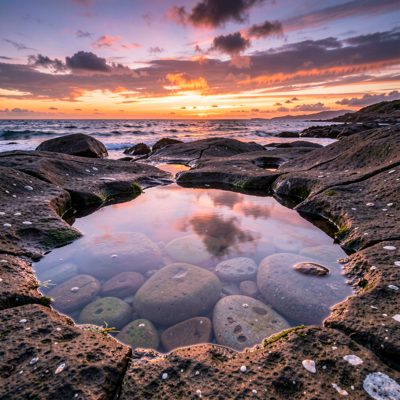 a rock pool reflecting the evening sky