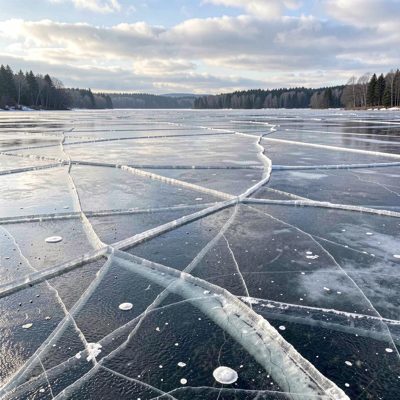a frozen lake with cracks across the surface