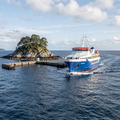 a ferry approaching a small island pier