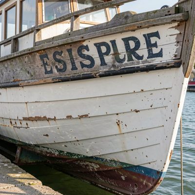 a weathered boat name painted on a hull