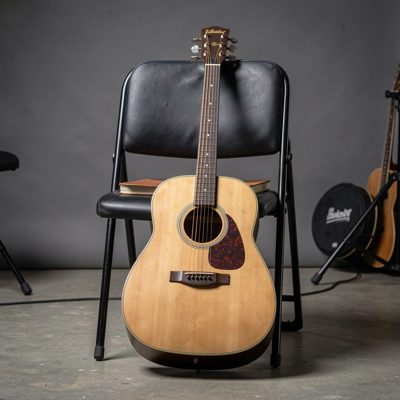 an acoustic guitar resting against a studio chair