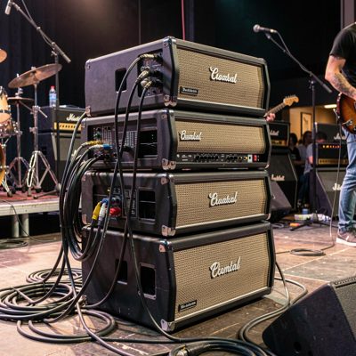 a stack of amplifiers and cables on a stage