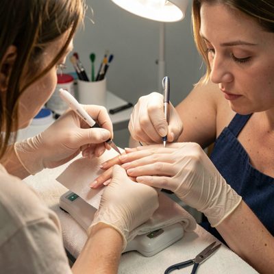a nail technician filing a client's nails