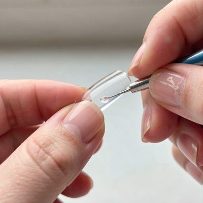 acrylic being shaped on a nail tip