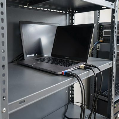 a laptop on a rack shelf connected to a switch console port