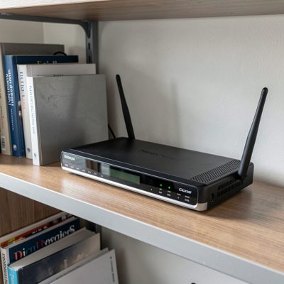 a cable modem and router on a shelf in a small office