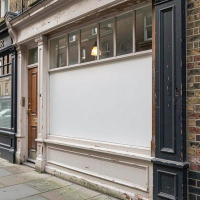 a period building shopfront with an empty painted sign board, blank empty sign board, no text, no lettering, no logo