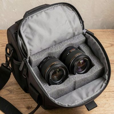 a camera bag open with lenses in foam