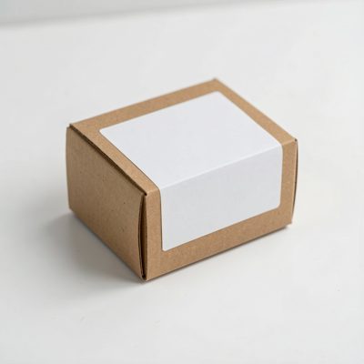 a small cardboard box with a blank unprinted white label on a white surface