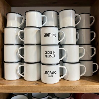 a set of enamel mugs stacked on a shelf