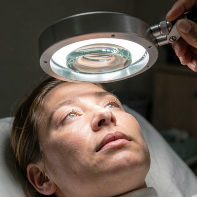 a magnifying lamp positioned over a face